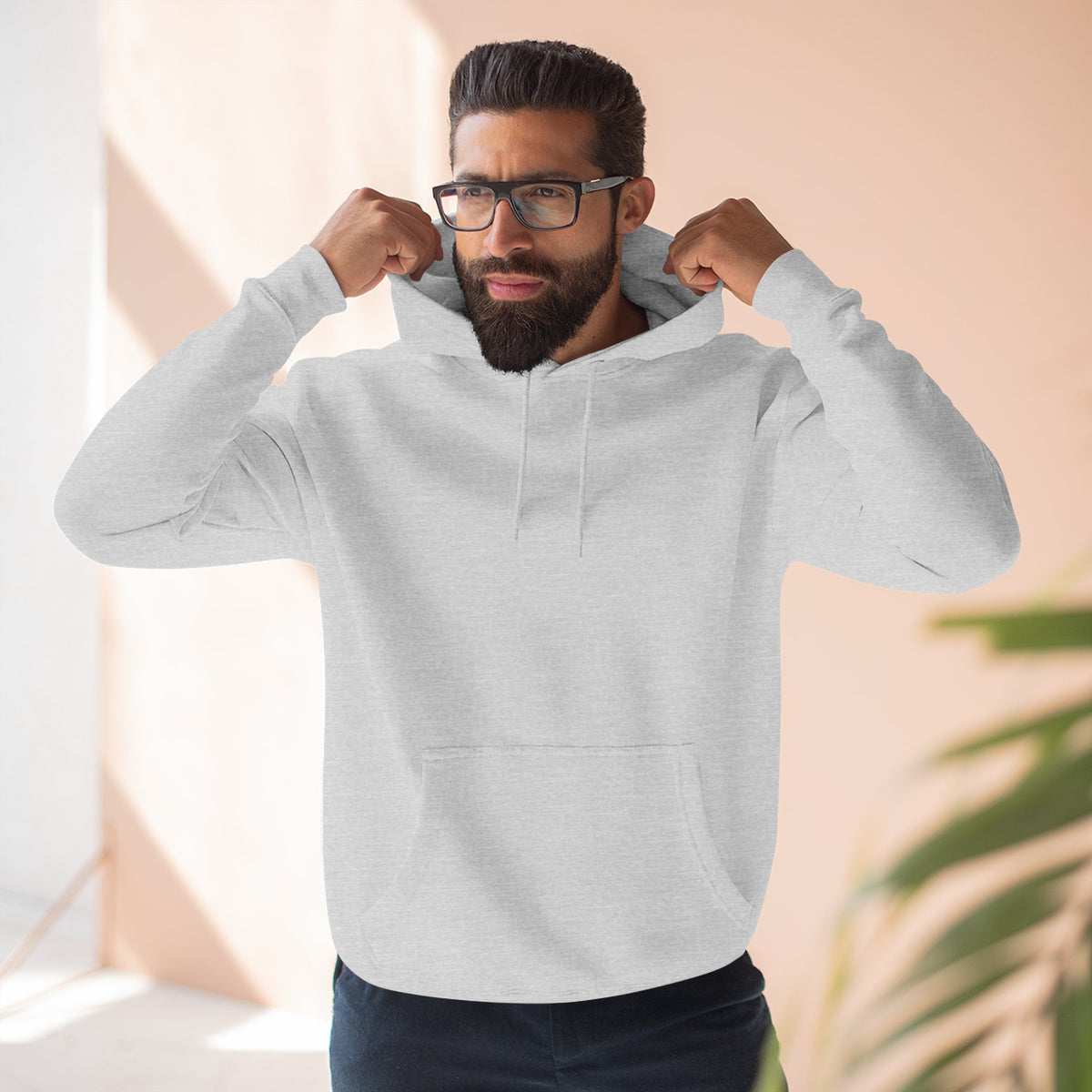 Man wearing a gray hoodie, standing indoors.